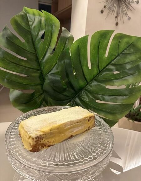 Fatia de bolo indiano fit com creme e canela servida em prato de vidro